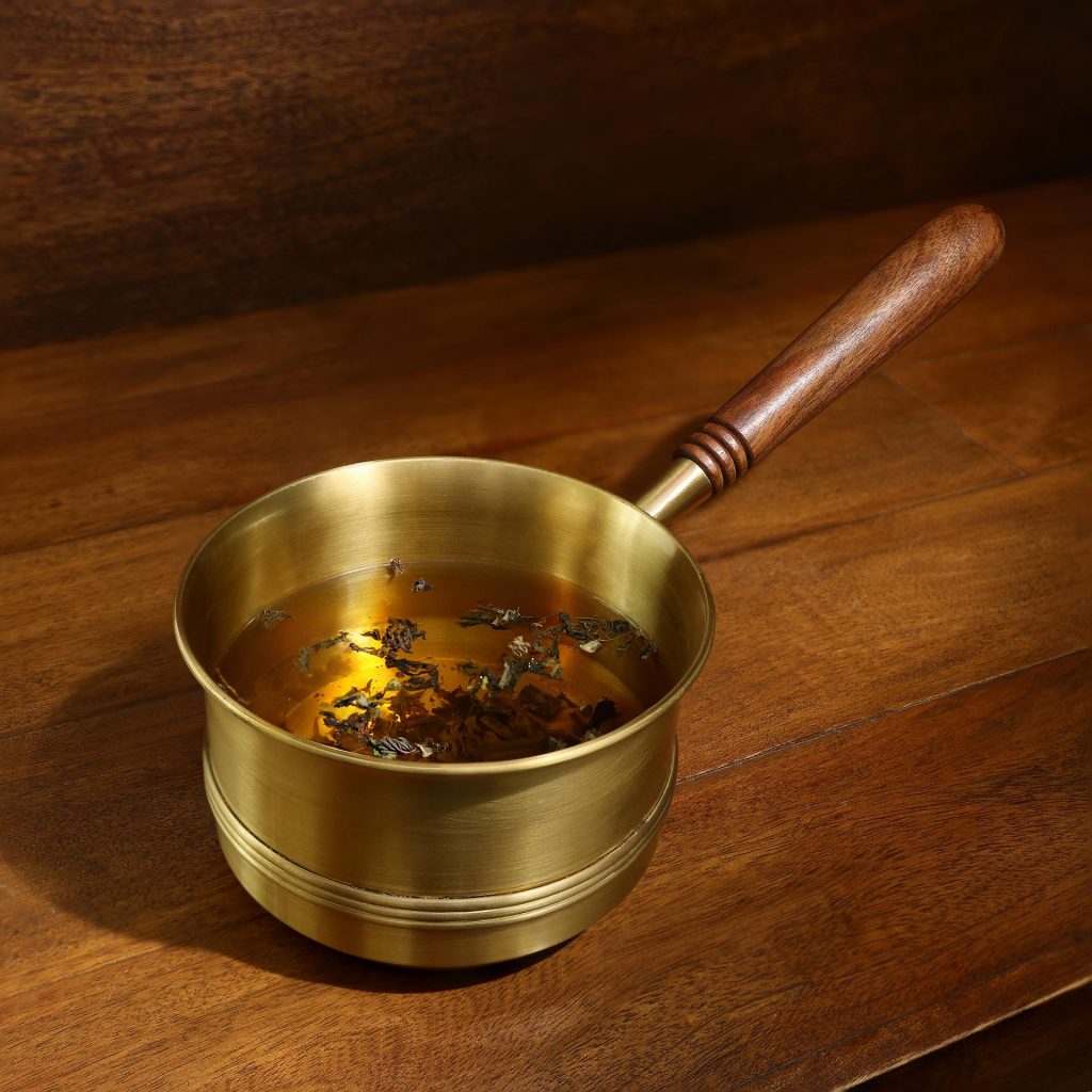 https://www.architectandinteriorsindia.com/cloud/2021/12/06/Arra-Brass-Tea-Pan-With-Wooden-Handle-2-1024x1024.jpg